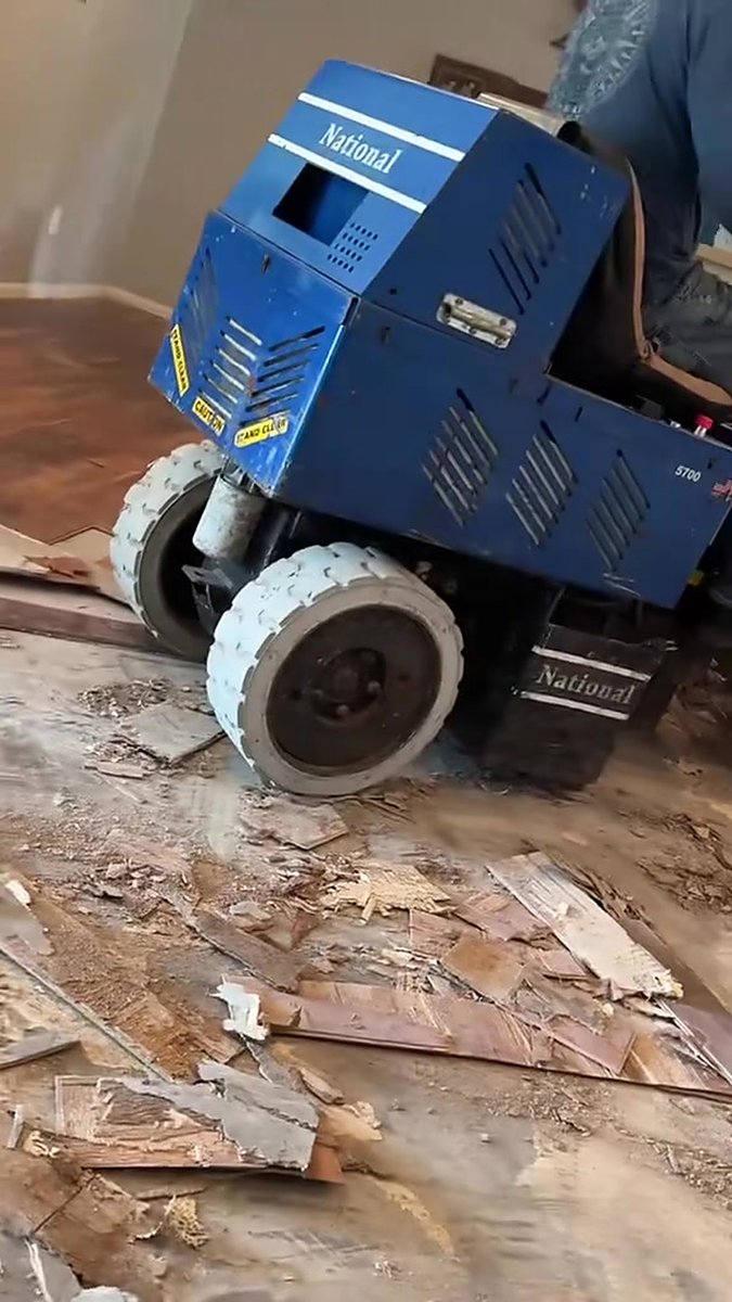 National 5700 battery-powered ride-on floor scraper stripping glued-down flooring inside a home