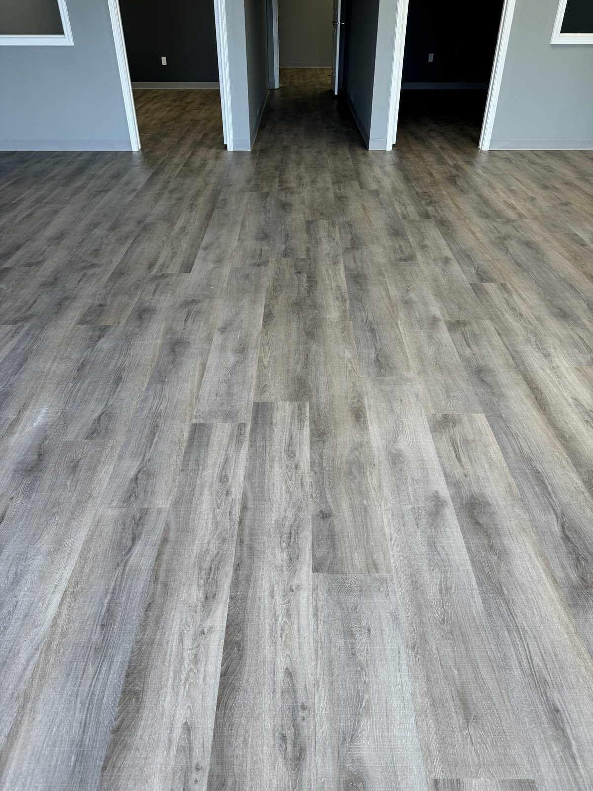 Gray luxury vinyl plank flooring running through an open living area